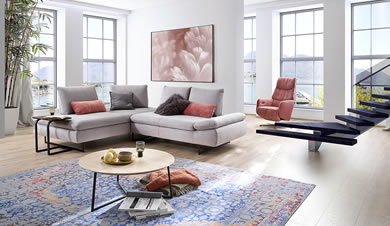 Ein modernes Wohnzimmer mit Ecksofa, Sessel und Couchtisch, inspiriert von Möbel Lutz aus Obernbreit.